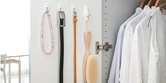 使用無痕™ 鐵上鉤將項鍊、皮帶和衣服刷掛在衣櫃門內側
