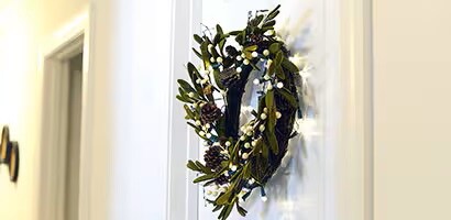 使用無痕透明掛鉤將聖誕花圈掛在房門上