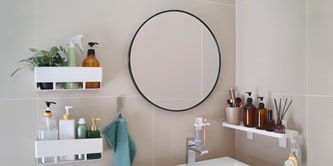 在浴室牆面使用無痕收納架、置物籃、牙刷架與掛勾來整理各種浴室用品
