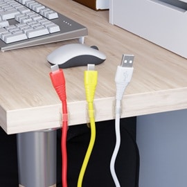 在電腦桌側面使用無痕透明電線掛勾來整理傳輸線