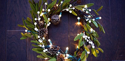 將燈飾纏繞在聖誕花環上
